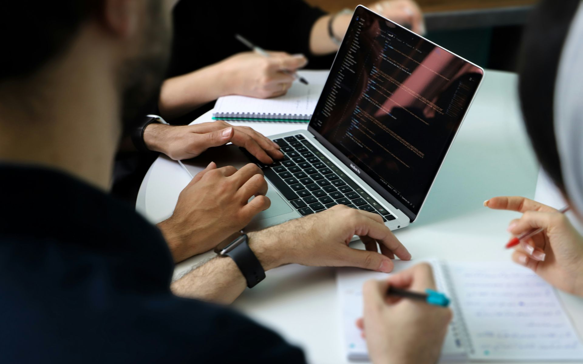 Team di professionisti che collabora attorno a un laptop durante una sessione di lavoro — AI, ROI e competenze aziendali