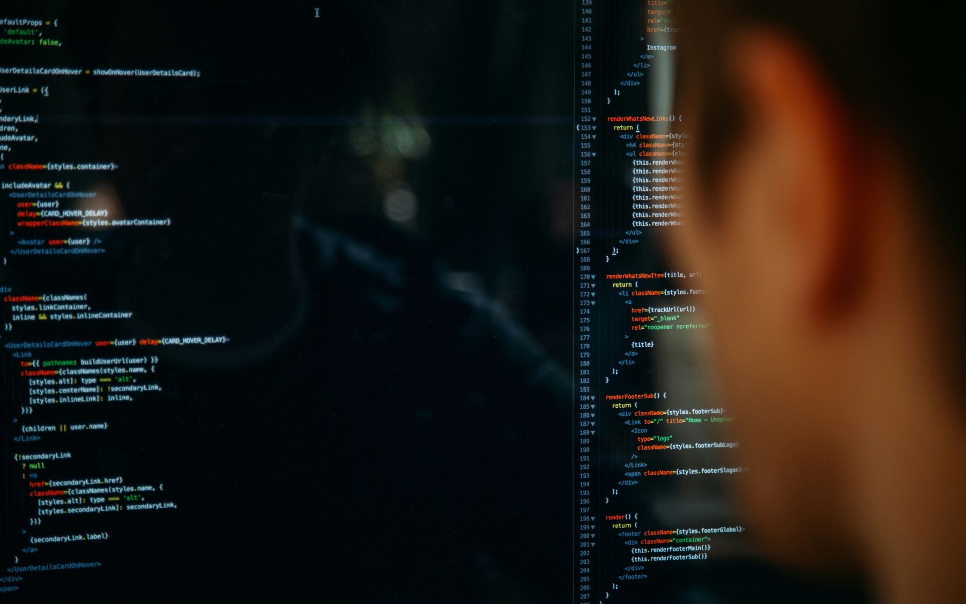 Schermo con codice di programmazione su sfondo scuro e sviluppatore sfocato in primo piano, simbolo del settore tech al centro del fenomeno AI washing
