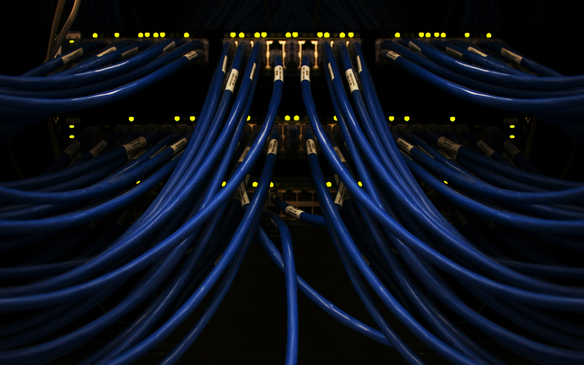 Cavi di rete blu collegati a un rack di server che si diramano in più direzioni, metafora del routing tra più modelli AI