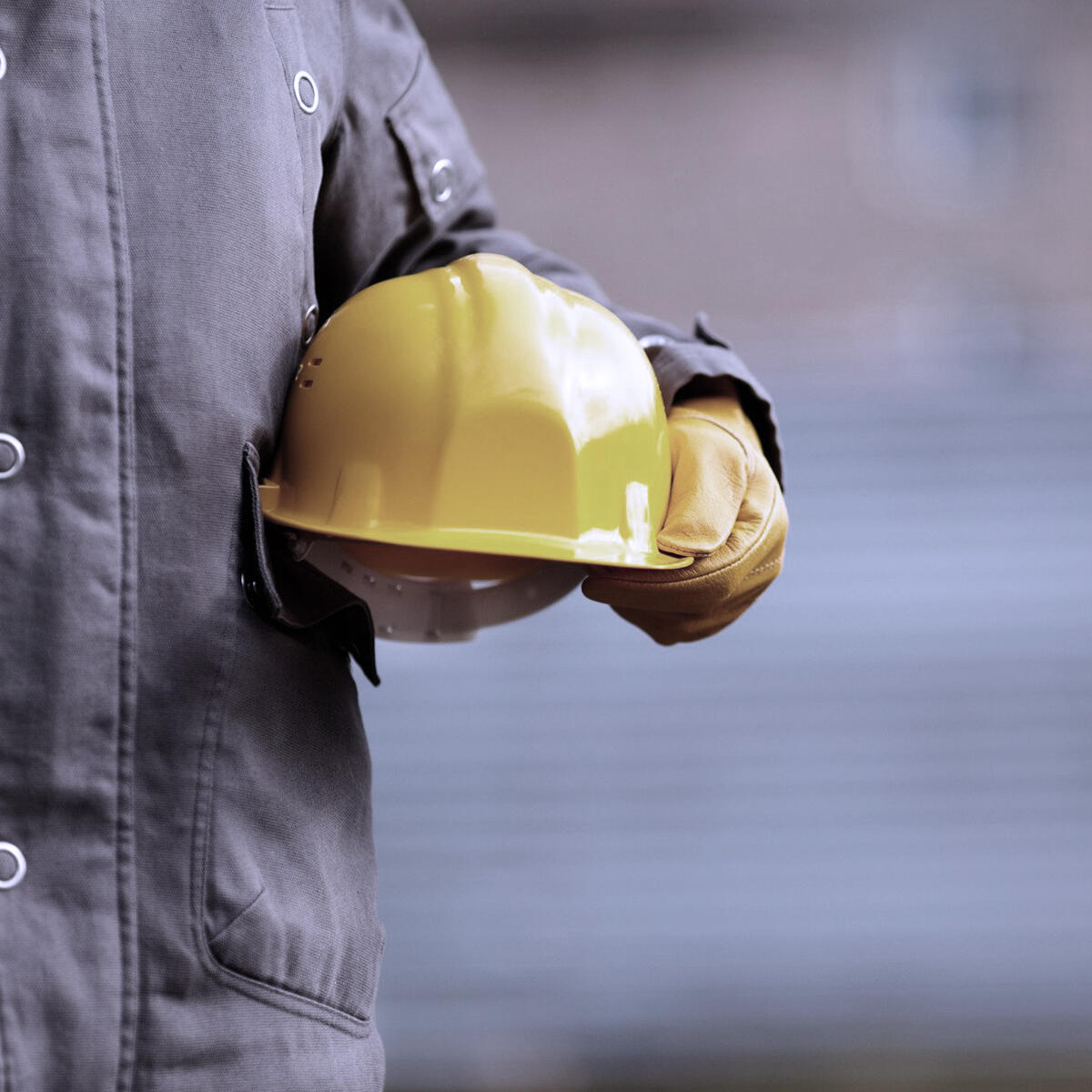Operaio che tiene in mano il suo casco protettivo giallo
